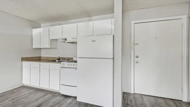 White cabinets refrigerator stove sink kitchen interior at Wind River Place Apartments in Colorado Springs Student Accommodation