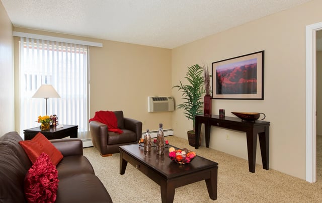Brown sofa armchair coffee table lamp living room at Wind River Place Apartments in Colorado Springs Student Accommodation