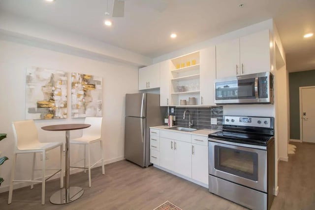 Table chairs modern kitchen appliances with artwork kitchen at 1515 Flats in Denver Student Accommodation