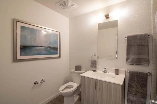 Framed art toilet vanity sink and towels bathroom at 1515 Flats in Denver Student Accommodation