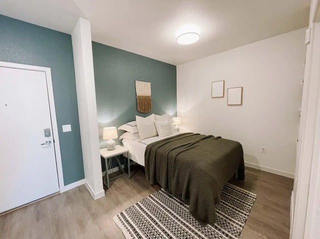 Bed with green blanket and two lamps Bedroom at 1515 Flats in Denver Student Accommodation