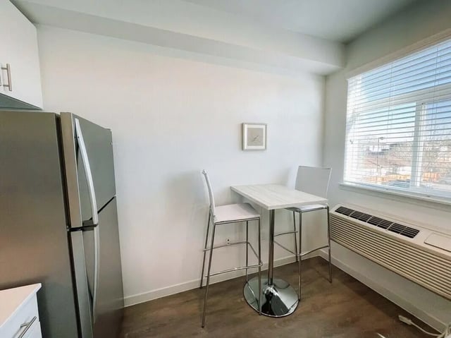 Refrigerator bar table two chairs kitchen area at 1515 Flats in Denver Student Accommodation