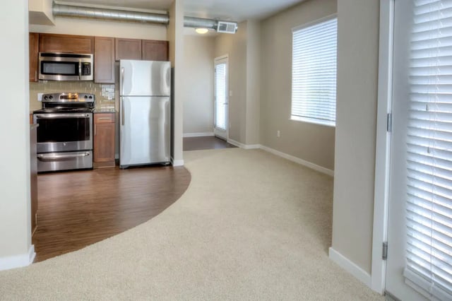 Kitchen and living area with appliances and blinds at Uptown Broadway in Boulder Student Accommodation