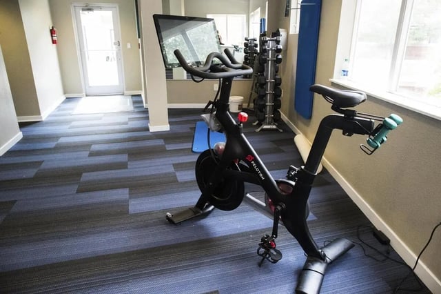 Peloton bike dumbbells mat exercise area at Uptown Broadway in Boulder Student Accommodation