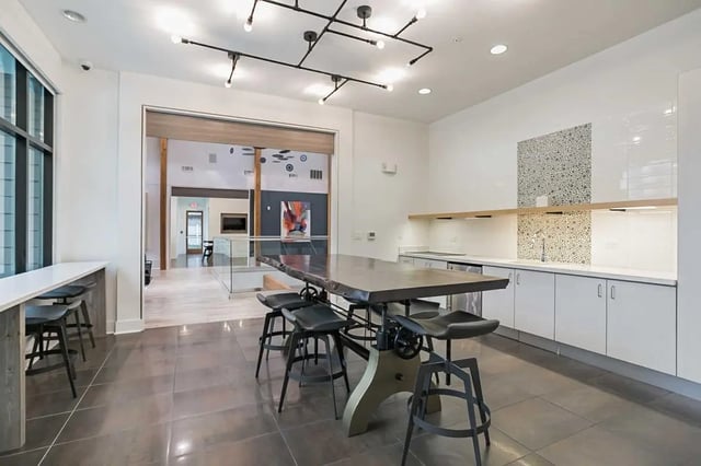 Large table with stools and kitchen area Common area at Copper Social in Marietta Student Accommodation