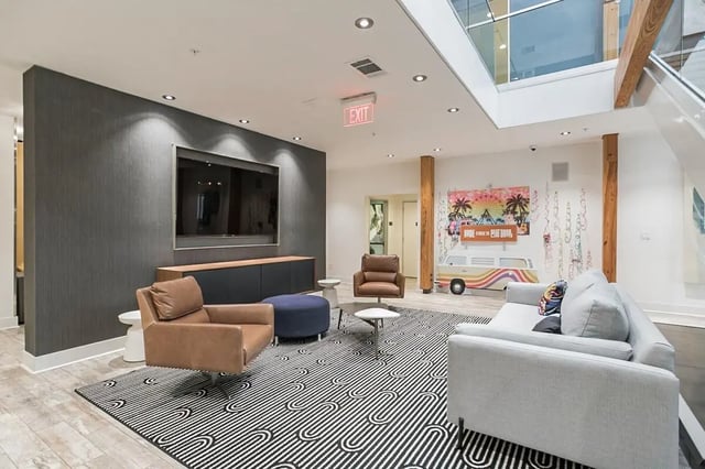 Two leather chairs grey sofa patterned rug living room at Copper Social in Marietta Student Accommodation