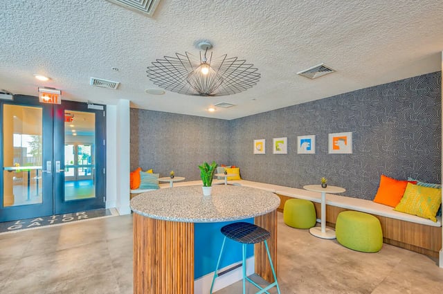 Circular table banquette seating and stools common area at Alsander GNV in Gainesville Student Accommodation