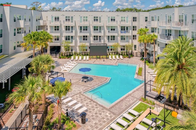 Courtyard pool lounge chairs and movie screen exterior at Alsander GNV in Gainesville Student Accommodation
