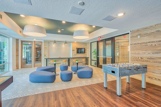 Foosball table blue ottomans lounge living area at Alsander GNV in Gainesville Student Accommodation
