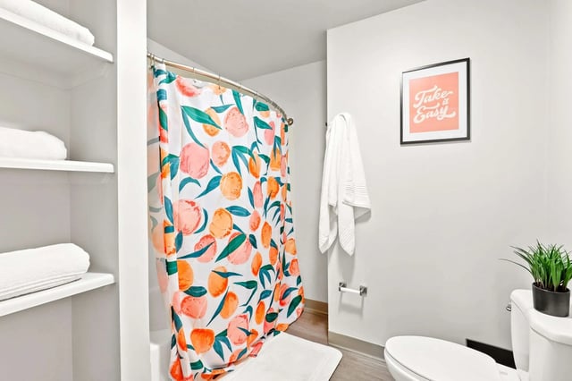 Towel shelves floral shower curtain framed art bathroom at Auraria Student Loft in Denver Student Accommodation