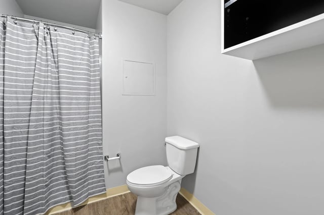 Toilet and striped shower curtain bathroom at Auraria Student Loft in Denver Student Accommodation