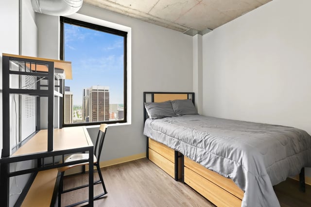 Desk bed and chair with city view bedroom at Auraria Student Loft in Denver Student Accommodation