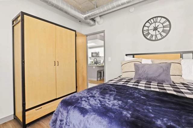 Closet bed clock and kitchen view bedroom at Auraria Student Loft in Denver Student Accommodation