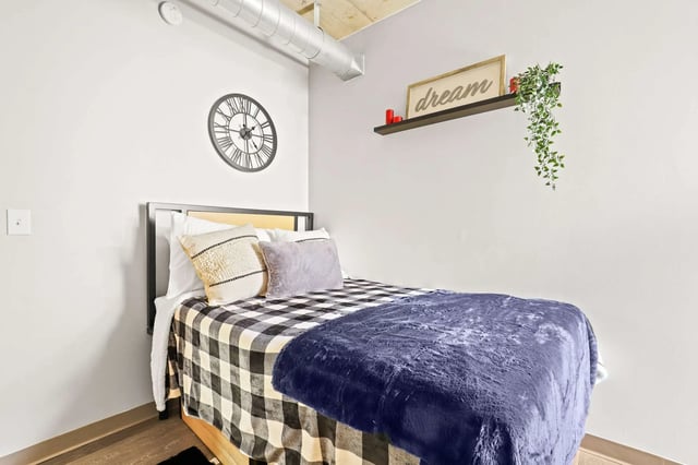 Bed with pillows and clock Bedroom at Auraria Student Loft in Denver Student Accommodation