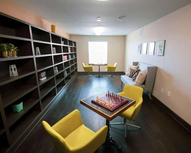 Chess board with yellow chairs and couch common area at Goodnight Commons in Austin Student Accommodation