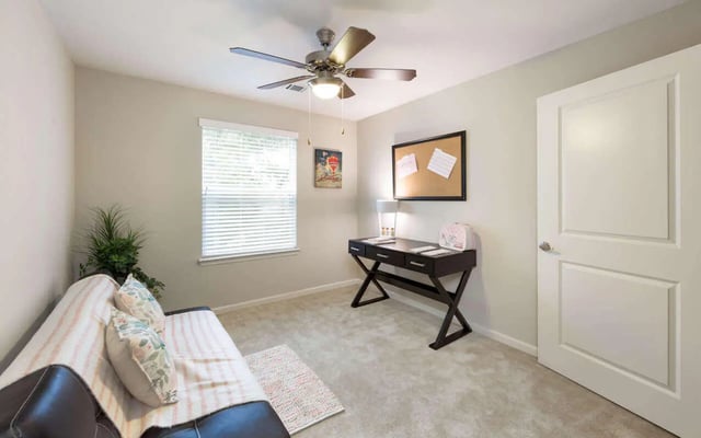 Sofa desk plant ceiling fan corkboard study area at Harris Branch Senior in Austin Student Accommodation