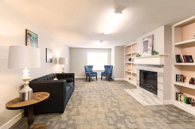 Sofa fireplace chairs and bookshelves living room at Harris Branch Senior in Austin Student Accommodation