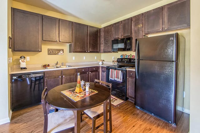 Kitchen with dark cabinets refrigerator oven microwave dining table kitchen at Harris Branch Senior in Austin Student Accommodation