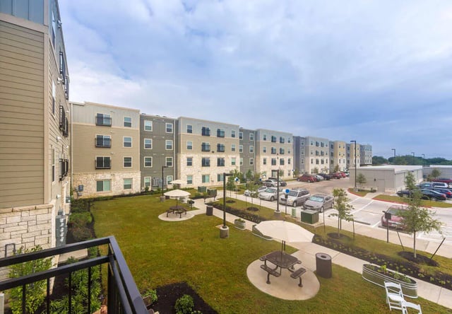 Apartment buildings with picnic areas and parking lot exterior at Harris Branch Senior in Austin Student Accommodation