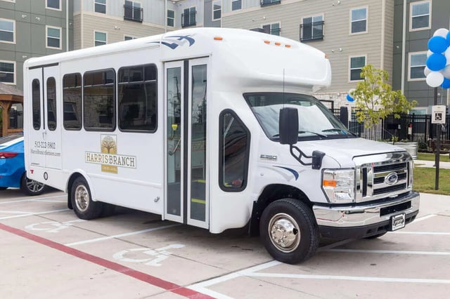 White shuttle bus with Harris Branch logo exterior at Harris Branch Senior in Austin Student Accommodation