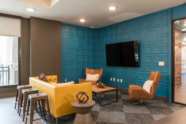 Yellow sofa brown chairs coffee table living room at Gateway on Cullen in Houston Student Accommodation