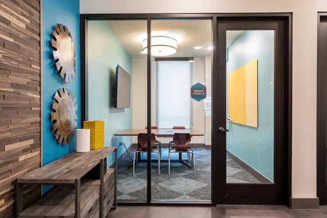 Table chairs television and yellow board study room at Gateway on Cullen in Houston Student Accommodation