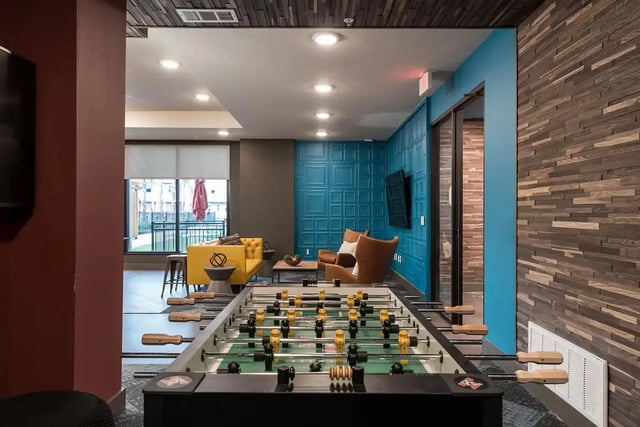 Foosball table yellow sofa brown chairs lounge area at Gateway on Cullen in Houston Student Accommodation