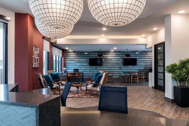 Chairs TVs tables and seating area common room at Gateway on Cullen in Houston Student Accommodation