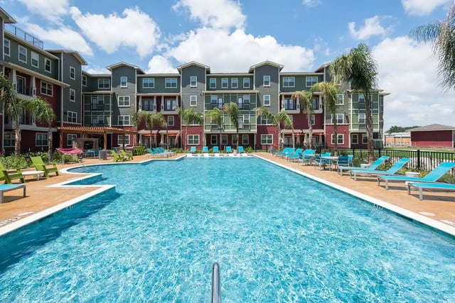 Apartment building with pool lounge chairs and tables exterior at Gateway on Cullen in Houston Student Accommodation