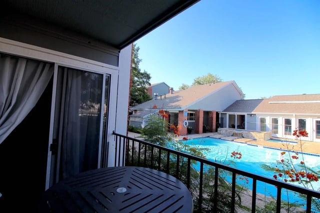 Balcony with table and pool view exterior at Ironhorse Flats in Austin Student Accommodation