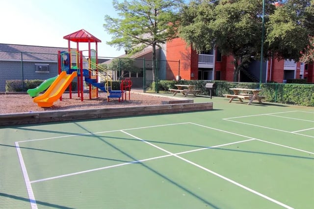 Playground with slides and picnic tables outdoor area at Ironhorse Flats in Austin Student Accommodation