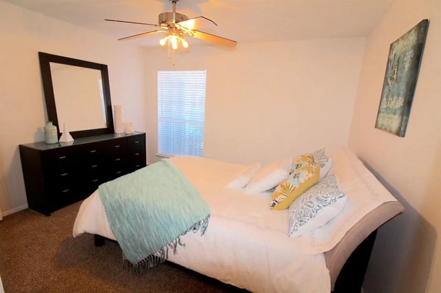 Bed dresser mirror ceiling fan artwork bedroom at Ironhorse Flats in Austin Student Accommodation