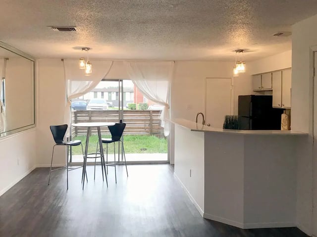 Table with two bar stools kitchen area living room at Ironhorse Flats in Austin Student Accommodation