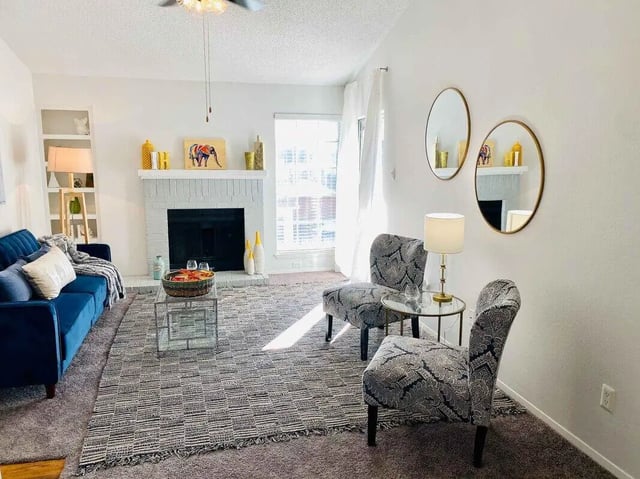 Blue sofa fireplace two chairs rug living room at Ironhorse Flats in Austin Student Accommodation