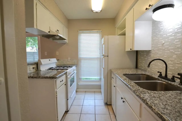 White cabinets stove sink refrigerator kitchen at Lightsey Place Apartments in Austin Student Accommodation