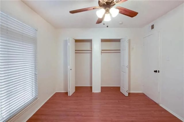 Two open closets ceiling fan wood floor bedroom at Lightsey Place Apartments in Austin Student Accommodation