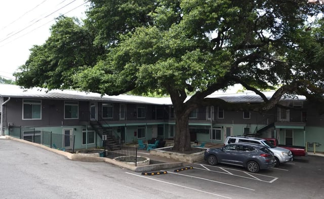 Apartment building with cars and chairs Exterior at Lightsey Place Apartments in Austin Student Accommodation