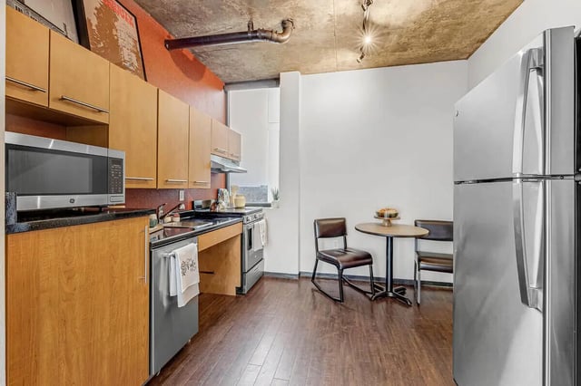 Microwave cabinets refrigerator table chairs kitchen at Vista in Denver Student Accommodation