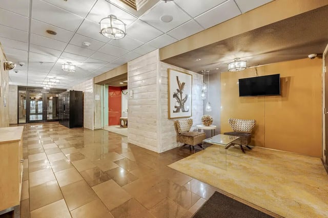 Two chairs TV art and rug lobby area at Vista in Denver Student Accommodation