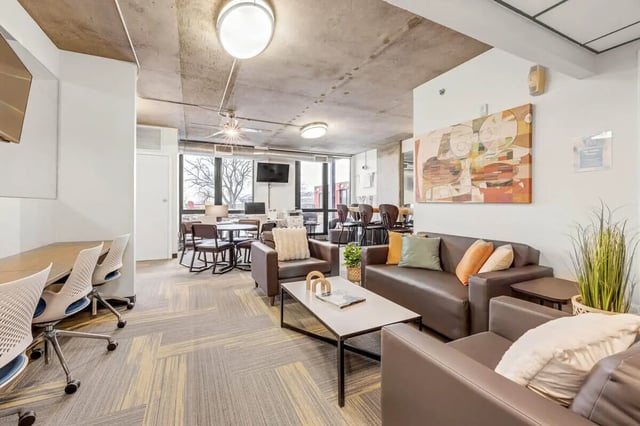 Brown couches coffee table chairs and tables living room at Vista in Denver Student Accommodation