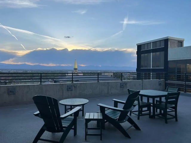 Adirondack chairs and tables on rooftop balcony exterior at Vista in Denver Student Accommodation