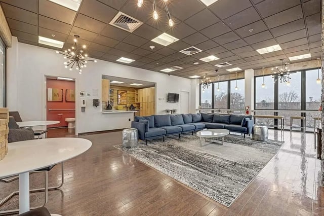 Large sectional couch round coffee table living room at Vista in Denver Student Accommodation