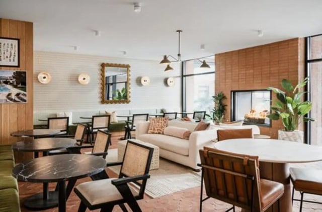 Modern lounge with sofas tables fireplace and plants living room at Rambler Austin in Austin Student Accommodation