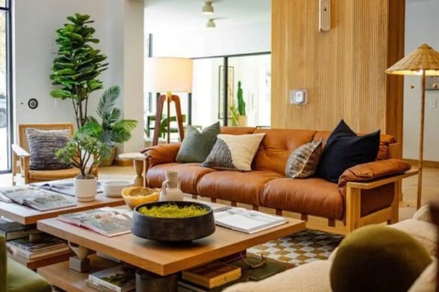 Leather sofa plants wooden tables living room at Rambler Austin in Austin Student Accommodation