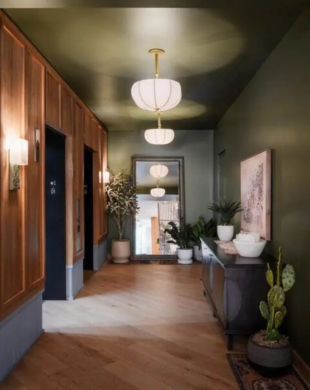 Hallway with wood paneling plants and dresser hall exterior at Rambler Austin in Austin Student Accommodation
