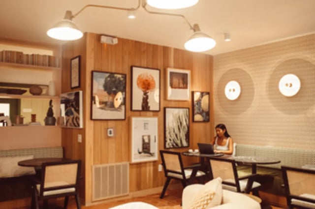 Woman working on laptop at communal seating area at Rambler Austin in Austin Student Accommodation