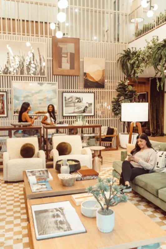 Two women and sofas in a common area living room at Rambler Austin in Austin Student Accommodation