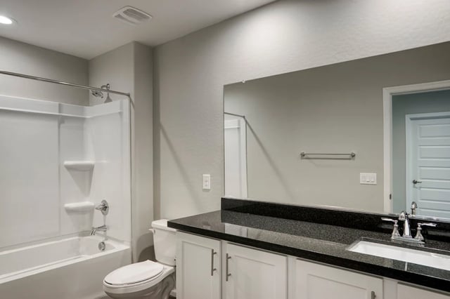 White bathtub toilet white vanity black granite bathroom at BB Living at Val Vista in Gilbert Student Accommodation
