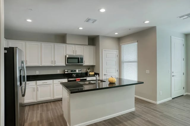 White cabinets refrigerator microwave island kitchen at BB Living at Val Vista in Gilbert Student Accommodation