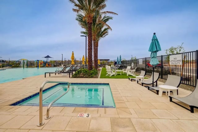 Pool and hot tub with lounge chairs and umbrellas amenity area at BB Living at Civic Square in Goodyear Student Accommodation